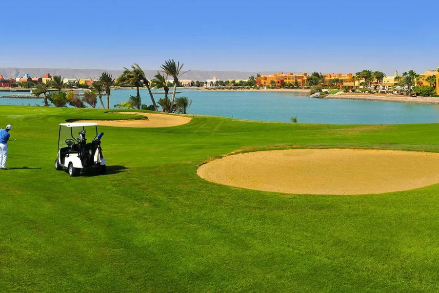 Golfer playing at El Gouna championship golf course near lagoon waterfront